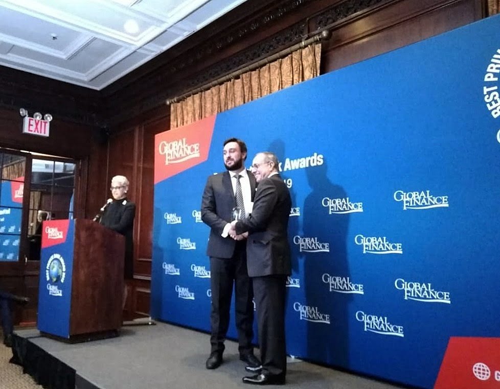 Luigi Wewege - SVP of Caye receiving Best Private Bank in Belize Award for 2019 from Global Finance publisher Joseph D. Giarraputo at The Harvard Club